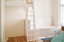 Bild 175: Hochbett mit individuellem Geländer und Bett mit Schubkästen, weiß lackiert