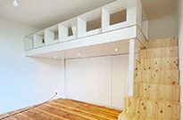 Bild 832: Hochbettebene in moderner Optik mit Treppenschrank, Regalgeländer und Kleiderschränken