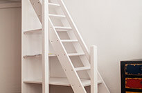 Bild 279: Große Treppe mit Handlauf und Treppenregal, weiß lackiert