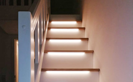 Bild 266: Treppenschrank mit beleuchteten Stufen, Türen und Auszüge / Schubkästen nach individuellen Vorgaben, einseitger Handlauf optisch aufgewertet mit Nuten, weiß lackiert
